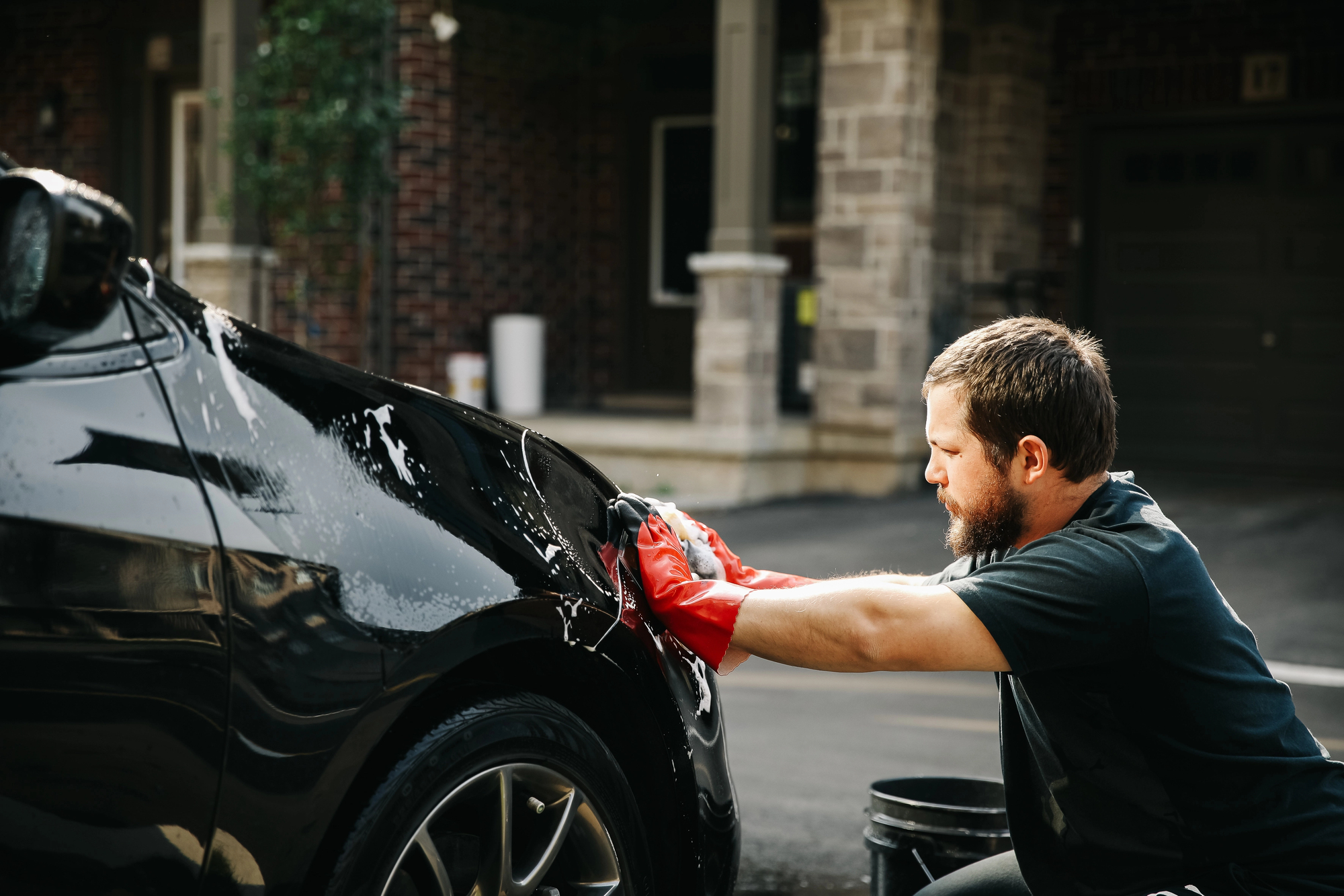 Quest detailing technician working on a black car